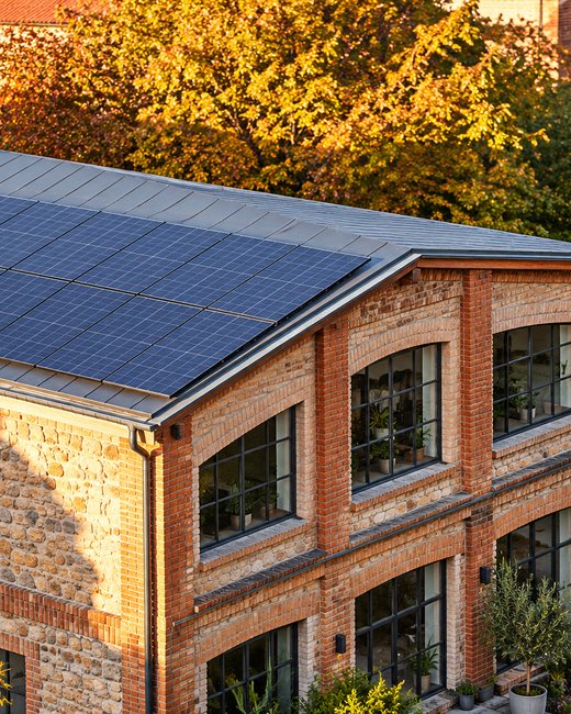 PV-Anlage auf dem Dach eines Gewerbegebäudes aus Backstein