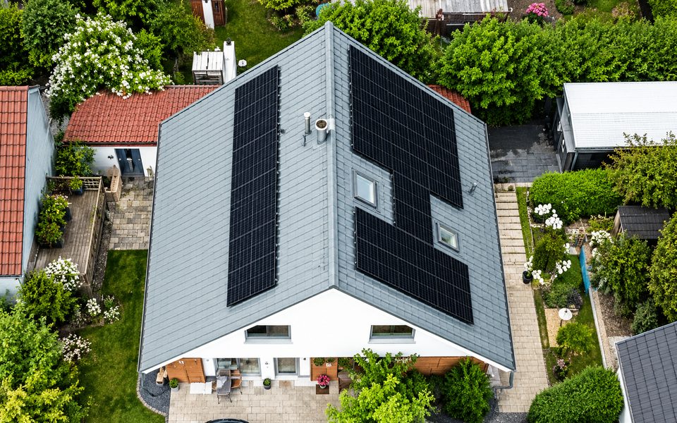 Luftaufnahme eines Wohnhauses mit großflächiger Photovoltaik-Anlage